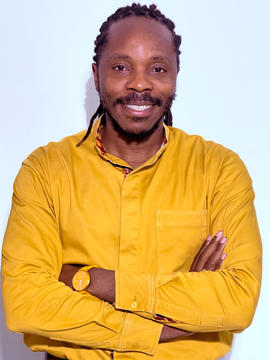 photograph of David Sengeh in a yellow shirt with arms crossed